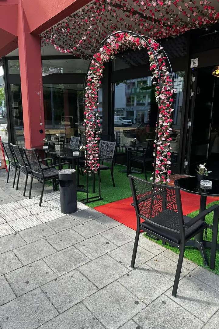 Terrasse vor der Middle East Lounge mit Blumenbogen, rotem Teppich und Sitzplätzen